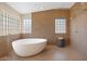 Spa-like bathroom featuring an elegant soaking tub, tiled walls, and modern fixtures at 4112 N 4Th Ave, Phoenix, AZ 85013