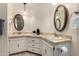 Bathroom featuring dual sinks with tile countertops, and decorative mirrors at 5221 E Mills Ct, Mesa, AZ 85215