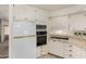 Bright kitchen features white cabinets, modern appliances, and tile countertops at 5221 E Mills Ct, Mesa, AZ 85215