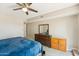 Bright bedroom features a ceiling fan, wood dresser, and light gray wood flooring at 5224 S Monaco Dr, Tempe, AZ 85283