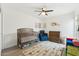 Bedroom with light wood floors, crib, blue chair, and a changing table at 5224 S Monaco Dr, Tempe, AZ 85283