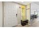 Bright entryway featuring a white front door, sidelight window, seating, coat hooks, and light wood-look flooring at 5224 S Monaco Dr, Tempe, AZ 85283