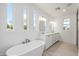 Luxurious bathroom with a soaking tub, double vanity, and bright natural lighting from the windows at 5537 E Earll Dr, Phoenix, AZ 85018