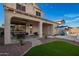 Covered patio, built-in grill, and seating area with backyard, artificial turf, and blue umbrella at 5628 N Rattler Way, Litchfield Park, AZ 85340