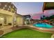 Beautiful backyard with a sparkling pool, an outdoor seating area, and lush artificial turf at 5628 N Rattler Way, Litchfield Park, AZ 85340