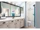 Bright bathroom featuring a single sink vanity, large mirror, and shower with glass door at 5628 N Rattler Way, Litchfield Park, AZ 85340