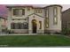 Inviting home facade with a well-kept lawn, stylish shutters, and an arched entryway at 5628 N Rattler Way, Litchfield Park, AZ 85340