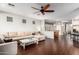 Spacious living area with hardwood floors, a large sectional sofa, and dining area access at 5628 N Rattler Way, Litchfield Park, AZ 85340