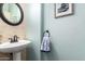 Stylish powder room boasts a pedestal sink, decorative mirror, and soothing blue wall color at 5628 N Rattler Way, Litchfield Park, AZ 85340