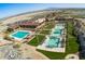 Breathtaking aerial view of pools, palm trees, and manicured landscaping against a backdrop of mountains and desert scenery at 5633 N 206Th Ave, Buckeye, AZ 85396