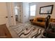 Cozy bedroom featuring a leather sofa, a decorative rug, and view into another bedroom at 5633 N 206Th Ave, Buckeye, AZ 85396