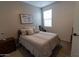 Cozy bedroom with neutral decor, framed art, and a large window at 5633 N 206Th Ave, Buckeye, AZ 85396