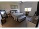 Comfortable bedroom featuring a large window, TV, gray bed, and a full-length mirror adding a sense of space at 5633 N 206Th Ave, Buckeye, AZ 85396