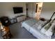 Comfortable bedroom featuring a large TV, dresser, and an open door to the bathroom for added convenience at 5633 N 206Th Ave, Buckeye, AZ 85396