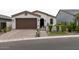 Charming single-Gathering home showcasing a black front door, brown garage door, and brick paver driveway at 5633 N 206Th Ave, Buckeye, AZ 85396