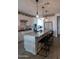 Modern kitchen boasts a large island with seating, stainless steel appliances, and stylish pendant lighting at 5633 N 206Th Ave, Buckeye, AZ 85396