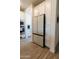 Kitchen with stainless steel refrigerator, shaker style cabinets, and hardwood style flooring at 5633 N 206Th Ave, Buckeye, AZ 85396