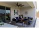 Inviting covered patio features comfortable seating, decorative wall art, and a ceiling fan for outdoor enjoyment at 5633 N 206Th Ave, Buckeye, AZ 85396