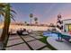 Outdoor living area with a fire pit, lounge seating, a pool, and manicured landscaping at 6518 W Louise Dr, Glendale, AZ 85310
