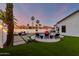 Lush backyard with artificial turf, pool, lounge seating, and lovely greenery at 6518 W Louise Dr, Glendale, AZ 85310