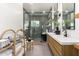 Modern bathroom with double sinks, wood cabinets, and a glass enclosed walk-in shower with rainfall shower head at 6518 W Louise Dr, Glendale, AZ 85310