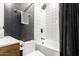 Stylish bathroom featuring a shower-tub combo with elegant fixtures and a modern black accent wall at 6518 W Louise Dr, Glendale, AZ 85310