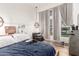 Comfortable bedroom boasts a modern pendant light fixture, large windows, and wood-style flooring at 6518 W Louise Dr, Glendale, AZ 85310