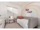 Cozy bedroom decorated with a rainbow mural, featuring a padded bed and a vanity with ample storage at 6518 W Louise Dr, Glendale, AZ 85310