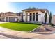 A well-maintained single-story home with desert landscaping and a neatly manicured artificial lawn at 6518 W Louise Dr, Glendale, AZ 85310