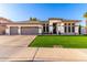 Beautiful single-story home with a manicured lawn, three-car garage, and neutral color palette at 6518 W Louise Dr, Glendale, AZ 85310