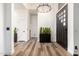 Clean and bright foyer with wood flooring, modern chandelier, and plant accents at 6518 W Louise Dr, Glendale, AZ 85310
