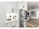 Modern kitchen features stainless steel refrigerator and sleek white cabinetry with black hardware at 6518 W Louise Dr, Glendale, AZ 85310