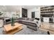 Spacious living room with a large sectional sofa, stylish bar area, and wood floors at 6518 W Louise Dr, Glendale, AZ 85310