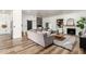 Open-concept living room featuring a cozy fireplace, custom bar, and stylish sectional sofa at 6518 W Louise Dr, Glendale, AZ 85310
