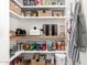 Walk-in pantry has wood shelves, wicker baskets, and an organized layout for storing food and supplies at 6518 W Louise Dr, Glendale, AZ 85310