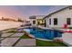 Backyard oasis with a sparkling pool, lush artificial turf, and inviting patio at 6518 W Louise Dr, Glendale, AZ 85310