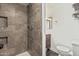 A shower stall in the bathroom features earthy toned ceramic tile, with a small vanity in view at 6812 N Polk St # 223, Phoenix, AZ 85043