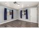 Bedroom featuring dark wood laminate flooring, blue curtains, and natural light at 6812 N Polk St # 223, Phoenix, AZ 85043