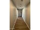 Hallway featuring hardwood flooring, neutral paint, and access to the water heater at 7007 S 45Th Pl, Phoenix, AZ 85042