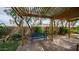 Outdoor living space with a patio featuring pavers, a pergola, and a blue bench surrounded by trees and bushes at 726 E Rose Marie Ln, Phoenix, AZ 85022
