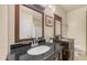 Bathroom with dual dark wood vanities, black granite countertops, and framed mirrors at 726 E Rose Marie Ln, Phoenix, AZ 85022