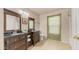 Bright bathroom featuring dark wood vanities, dual sinks, and plenty of storage space at 726 E Rose Marie Ln, Phoenix, AZ 85022
