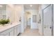 Bright bathroom featuring double sinks, sleek vanity, white cabinets, and a glass-enclosed shower at 7842 W Tether Trl, Peoria, AZ 85383