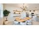 Elegant dining area with a modern chandelier, floating shelves, and views of the kitchen at 7842 W Tether Trl, Peoria, AZ 85383