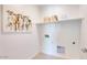 Clean and simple laundry room with space for appliances, shelving, and a decorative touch at 7842 W Tether Trl, Peoria, AZ 85383