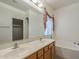 Well-lit bathroom featuring dual sinks, tub, and storage space at 7937 W Chickasaw St, Phoenix, AZ 85043