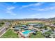 Aerial view of the community pool and tennis courts near green spaces and homes at 110 E Saddle Way, San Tan Valley, AZ 85143