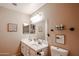 Neutral bathroom offering a double vanity sink, framed mirror, and toilet at 11746 W Camino Vivaz --, Sun City, AZ 85373