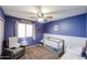 Charming bedroom with blue walls, white wainscoting, ceiling fan, and window for natural light at 11746 W Camino Vivaz --, Sun City, AZ 85373