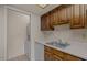 Well-lit kitchen area with white counters, wood cabinets, and access to laundry at 1402 E Guadalupe Rd # 215, Tempe, AZ 85283